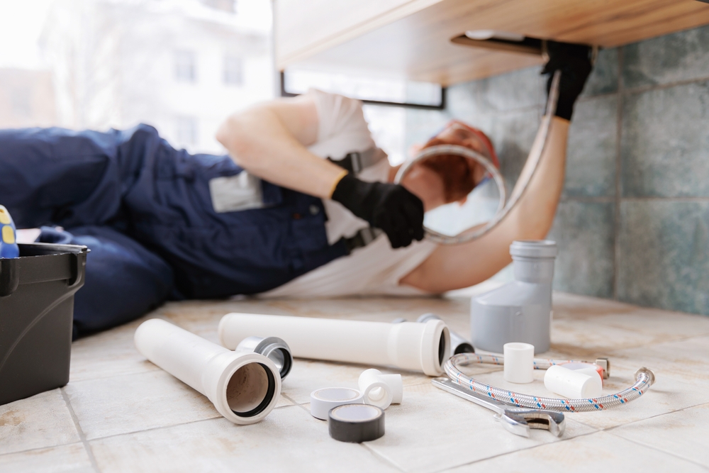 Plumber fixing common plumbing problems in a Tampa residential home kitchen