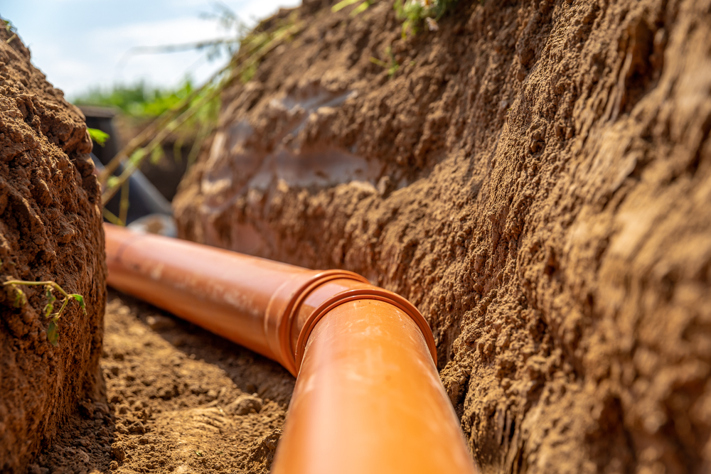 Professional plumber inspecting a Tampa sewer line backup after heavy afternoon storms